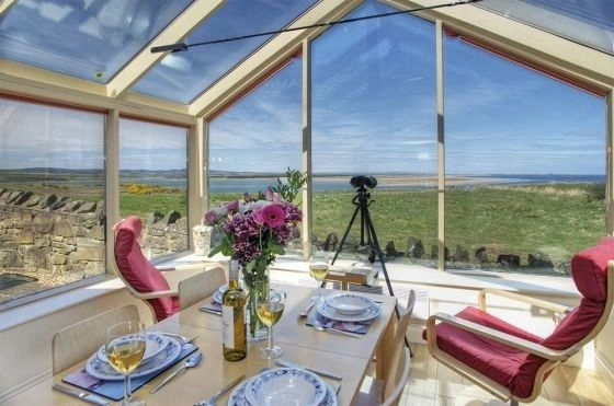 Conservatory dining with panoramic views over Budle Bay